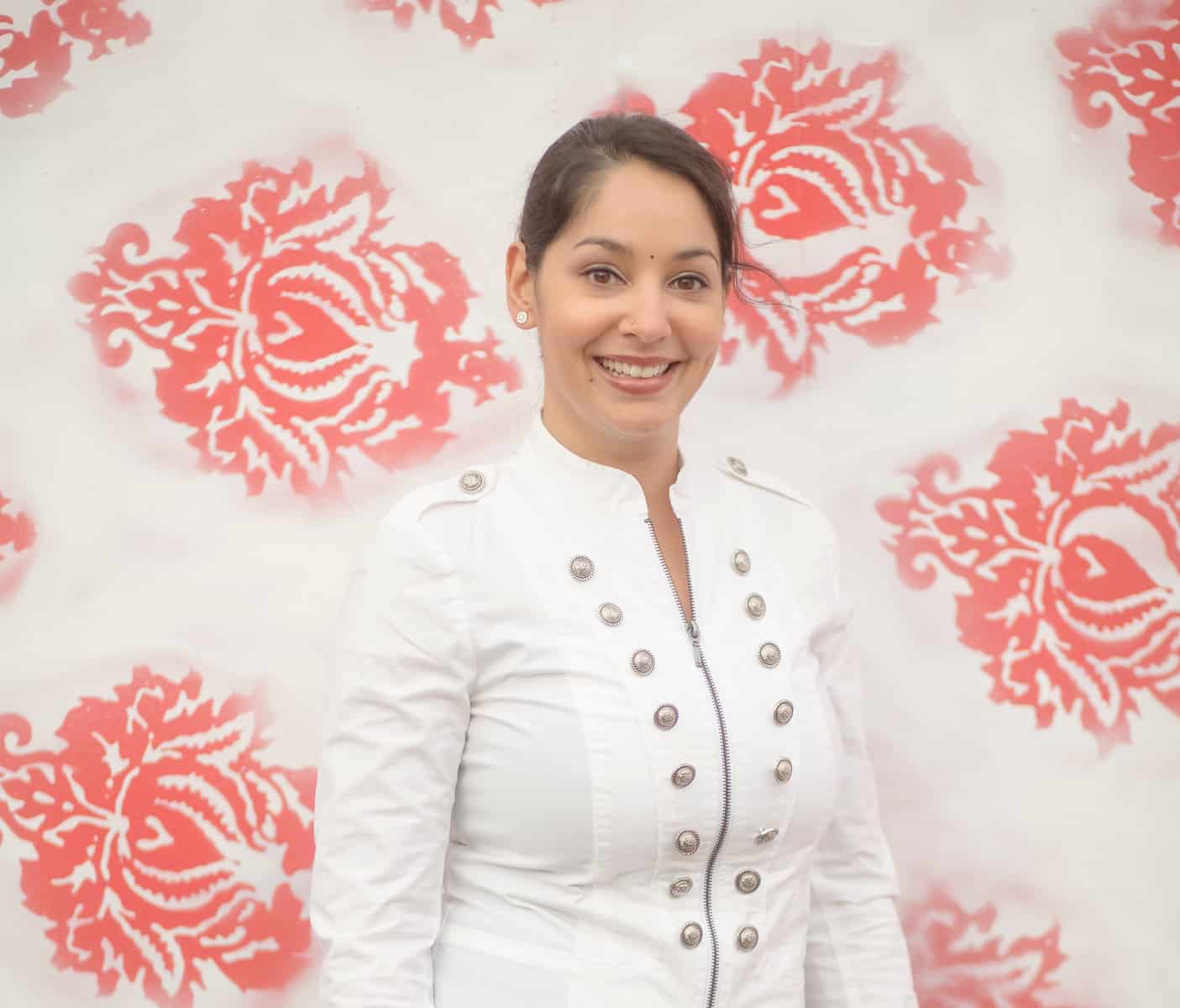 Headshot of Venita Sivamani against a Red Flower Wall